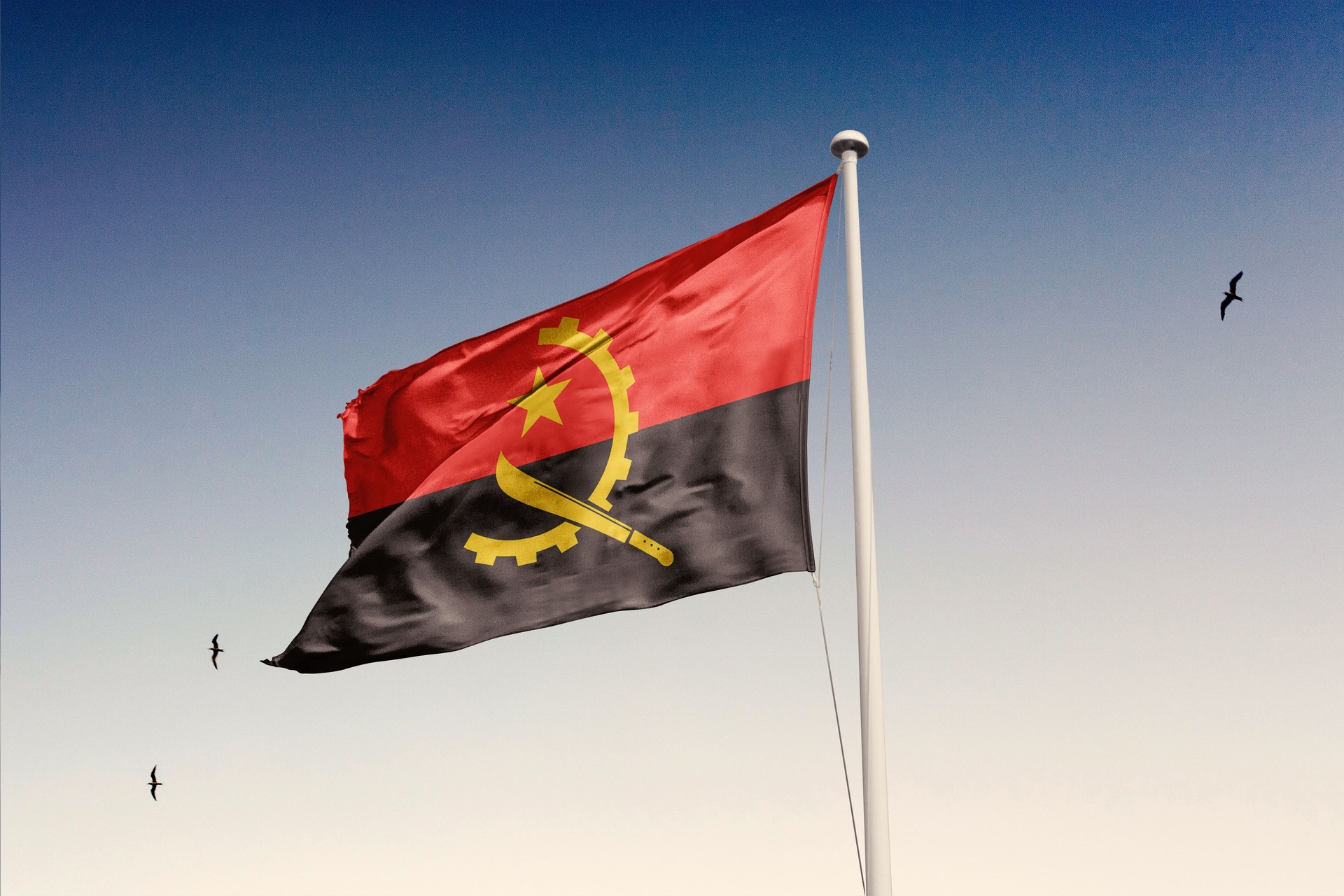 Angola flag fluttering in the wind on sky.